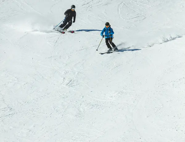 Ab Dezember 2026: glockna – das wohl coolste Hotel in Fusch Zwei Skifahrer fahren nebeneinander auf einer verschneiten Piste